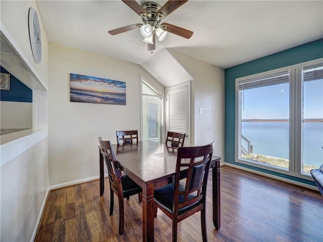 dining space featuring a water view, plenty of natural light, baseboards, and wood finished floors