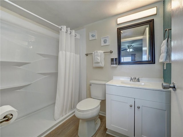 full bathroom with toilet, curtained shower, wood finished floors, and vanity