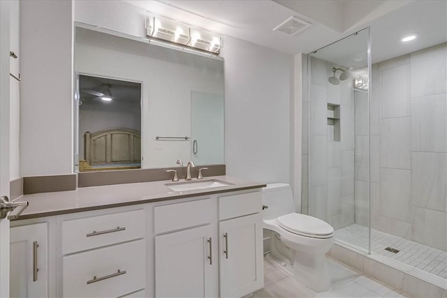 bathroom featuring vanity, toilet, and a tile shower