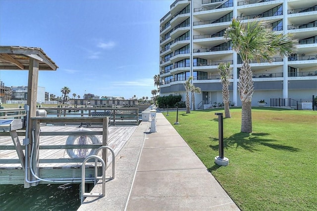 view of home's community with a water view and a yard