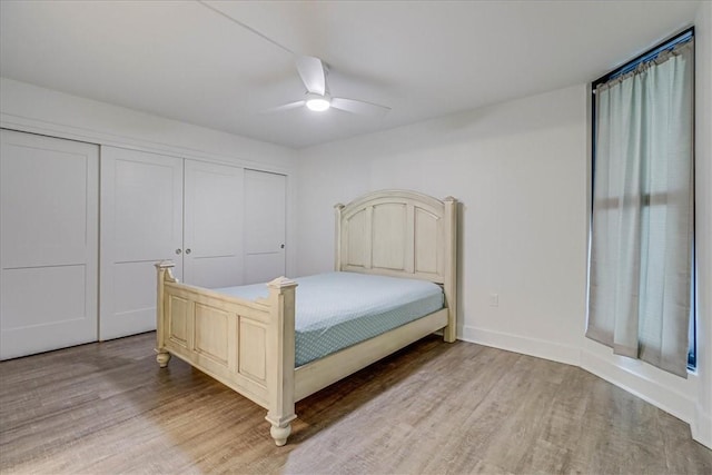 bedroom featuring ceiling fan, light wood-type flooring, and a closet