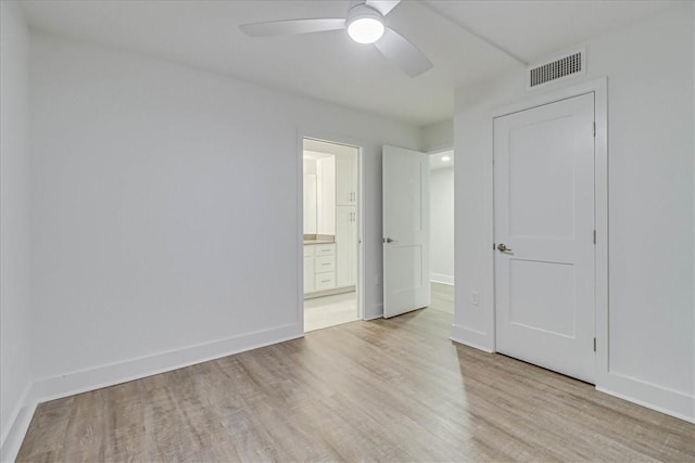 unfurnished bedroom featuring light hardwood / wood-style floors, ensuite bath, and ceiling fan