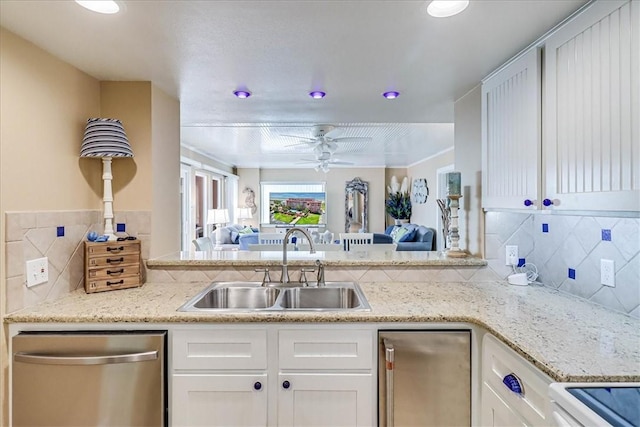 kitchen featuring refrigerator, dishwasher, sink, and white cabinets