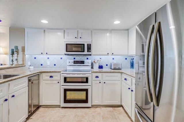 kitchen featuring backsplash, stainless steel appliances, and white cabinets