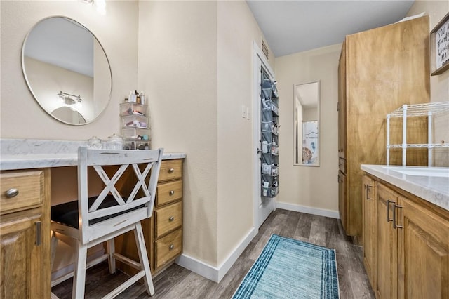bathroom featuring vanity, wood finished floors, and baseboards
