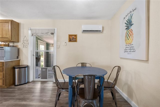 dining room with an AC wall unit, baseboards, and dark wood-type flooring