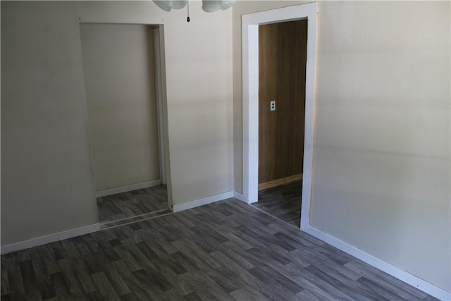 unfurnished bedroom with dark wood-type flooring and a closet