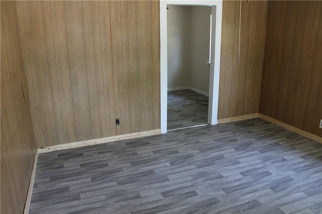 empty room with wood-type flooring and wooden walls