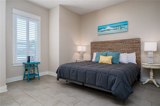 bedroom with multiple windows and light tile patterned flooring