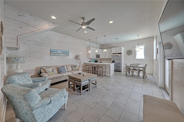 living room with wood walls and ceiling fan