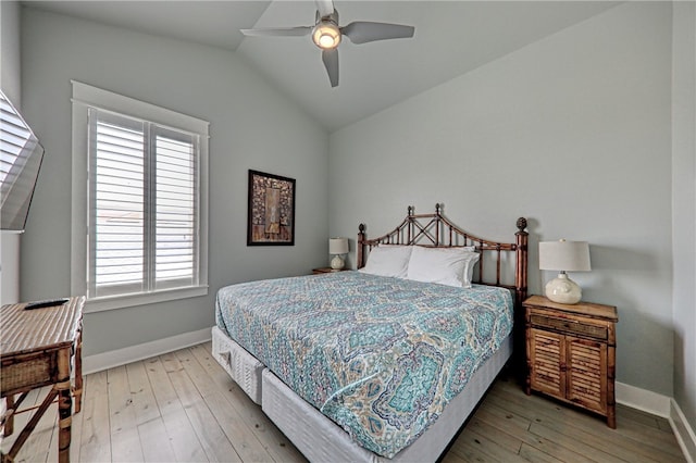 bedroom featuring hardwood / wood-style floors, ceiling fan, multiple windows, and vaulted ceiling