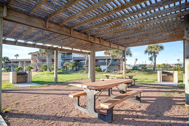 view of property's community featuring a pergola and a lawn