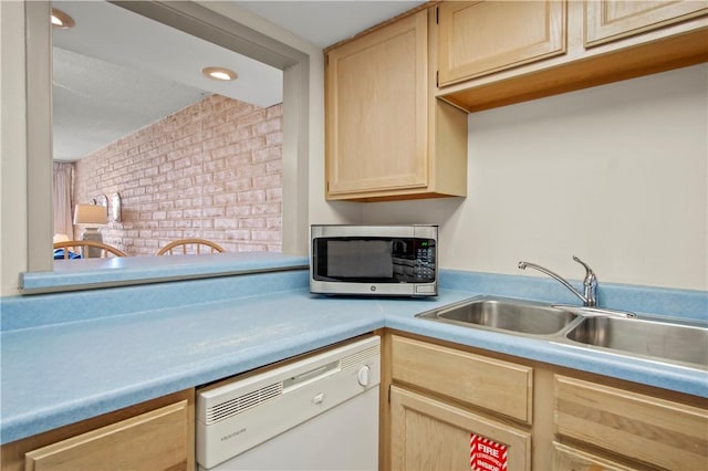 kitchen with white dishwasher, sink, and light brown cabinets