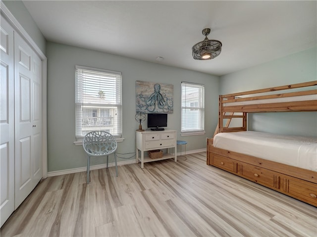 unfurnished bedroom featuring light hardwood / wood-style floors, multiple windows, and a closet