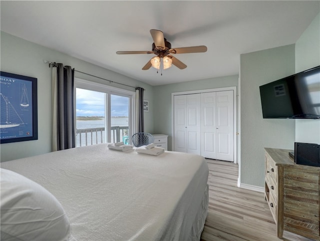 bedroom featuring access to outside, light hardwood / wood-style floors, ceiling fan, and a closet