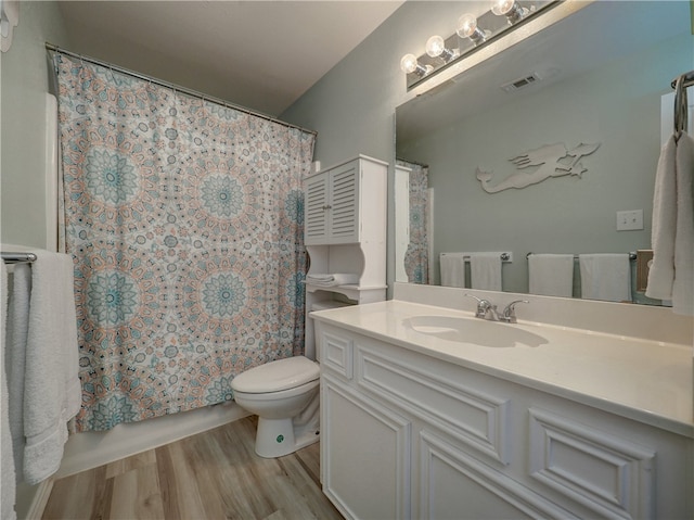 full bathroom with shower / bath combo with shower curtain, wood-type flooring, vanity, and toilet