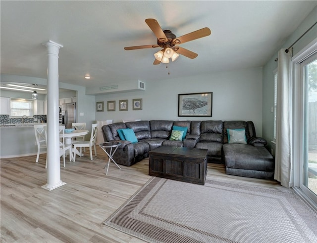 living room with ceiling fan, light hardwood / wood-style flooring, and decorative columns