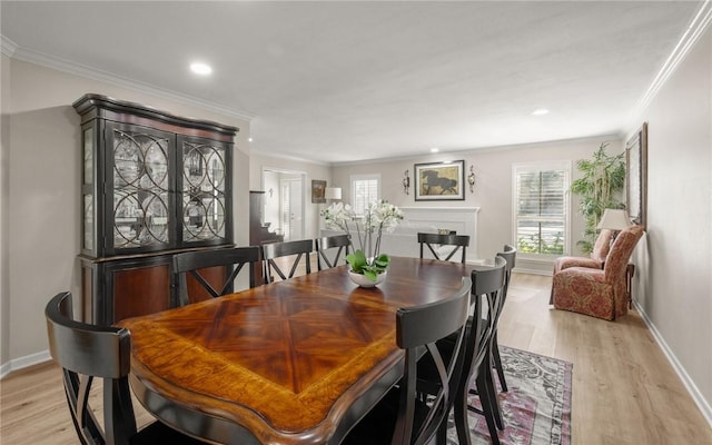 dining area with crown molding and light hardwood / wood-style floors