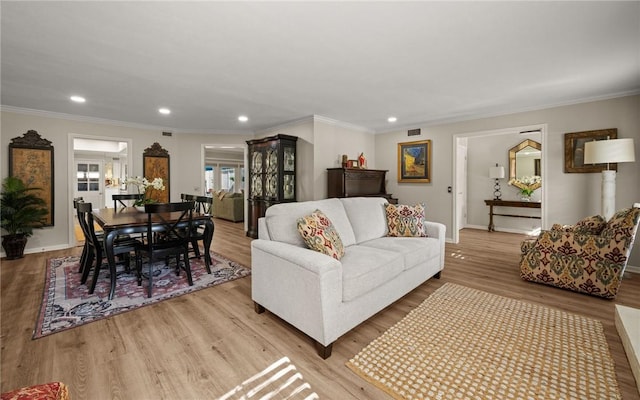 living room with crown molding and light wood-type flooring