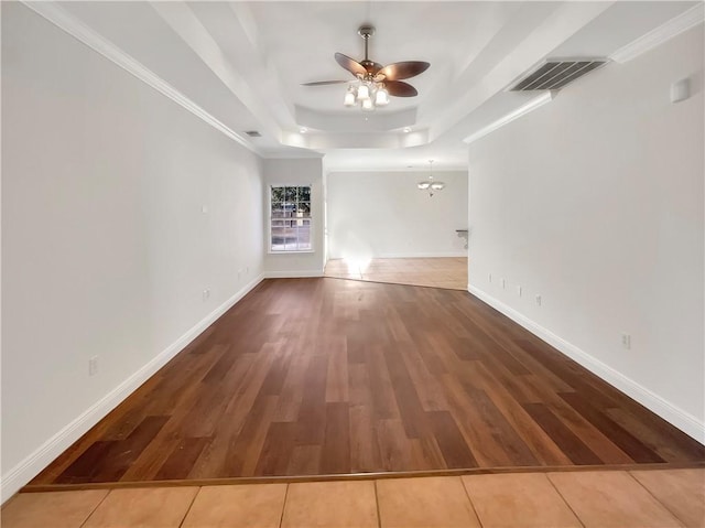 interior space featuring crown molding, ceiling fan, wood-type flooring, and a tray ceiling