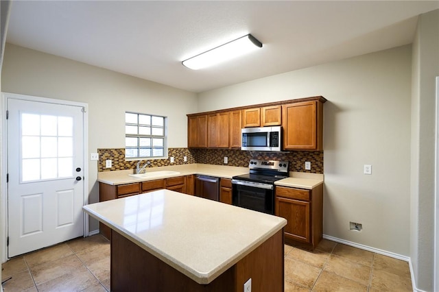 kitchen featuring appliances with stainless steel finishes, sink, a kitchen island, and backsplash