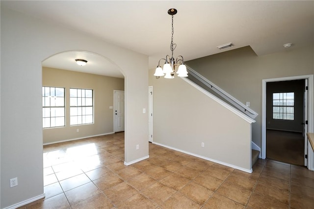 unfurnished dining area with light tile patterned flooring and an inviting chandelier