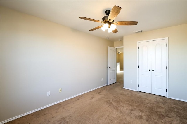 unfurnished bedroom featuring carpet, ceiling fan, and a closet