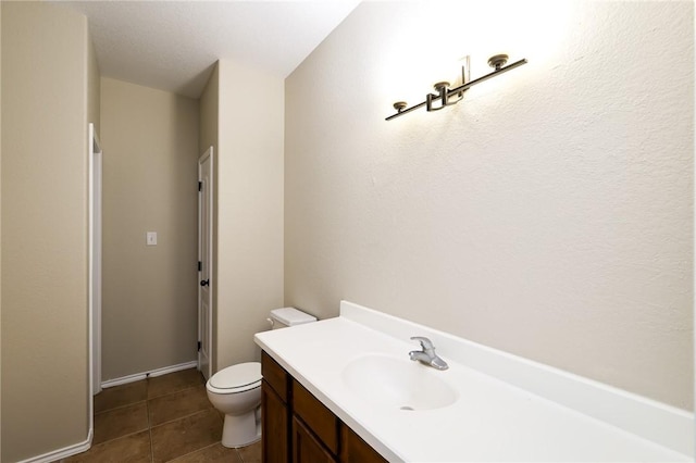 bathroom with tile patterned flooring, vanity, and toilet