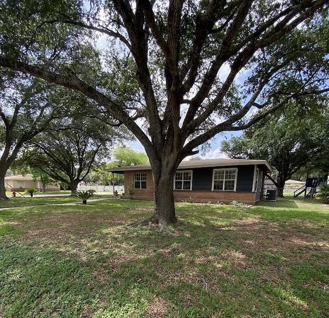 view of front of property with a front lawn and central AC unit