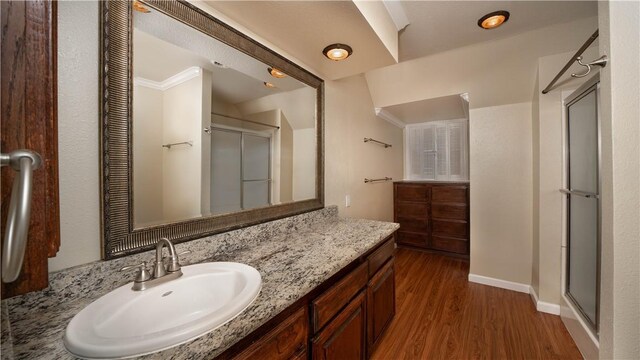 110 Amistad St, Corpus Christi, TX 78404 - bathroom with wood finished floors, a shower with door, vanity, and baseboards