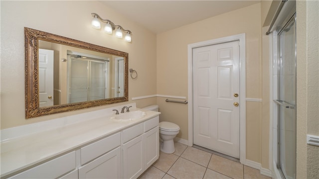 bathroom with toilet, an enclosed shower, vanity, and tile patterned floors