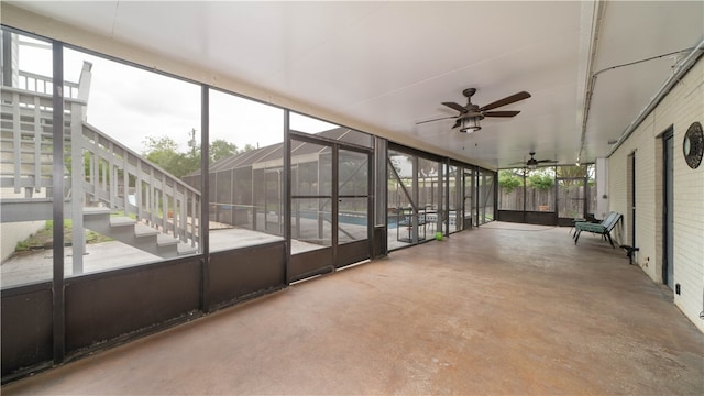 unfurnished sunroom featuring ceiling fan