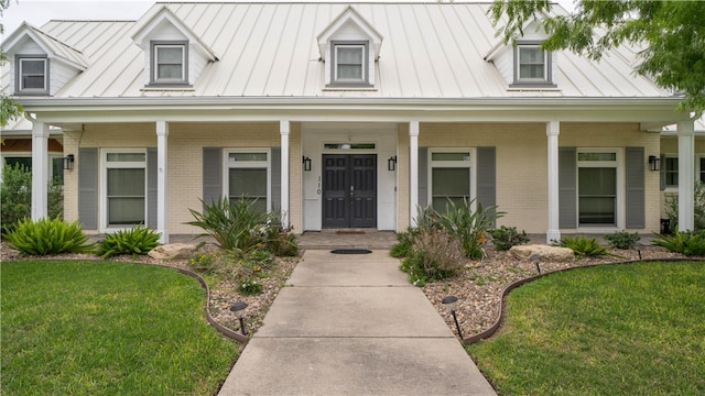 cape cod-style house with a front yard and a porch