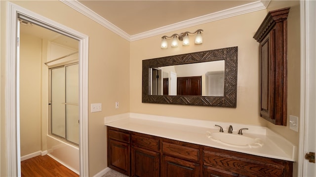 bathroom with hardwood / wood-style flooring, vanity, shower / bath combination with glass door, and crown molding