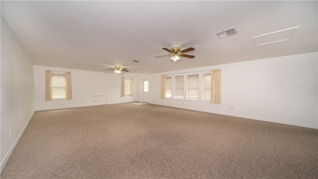 empty room featuring a wealth of natural light, ceiling fan, and carpet flooring