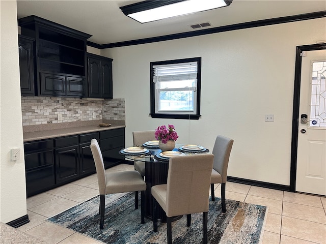 dining area featuring ornamental molding and light tile patterned flooring