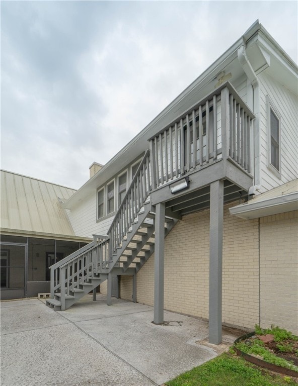 view of property exterior with a sunroom and a patio area