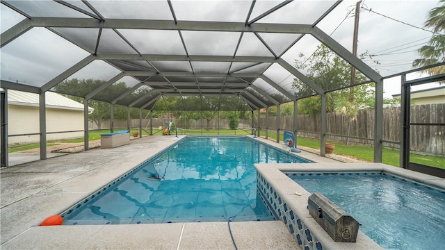 view of pool with glass enclosure and a patio area