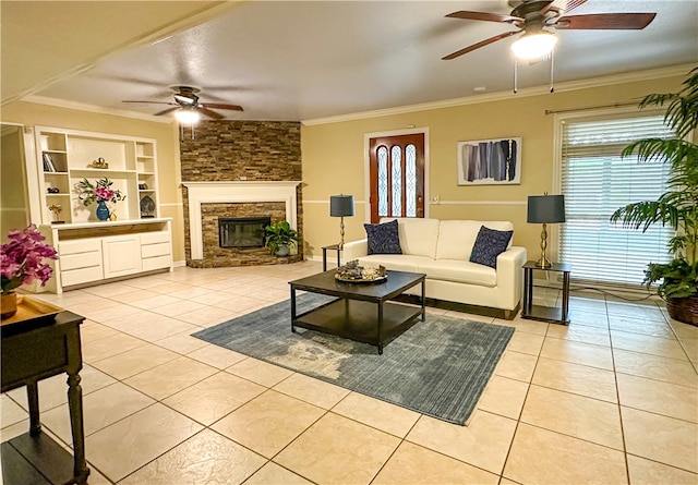 living room with a fireplace, ceiling fan, light tile patterned floors, and crown molding