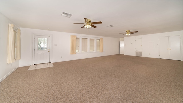 unfurnished living room featuring light carpet and ceiling fan