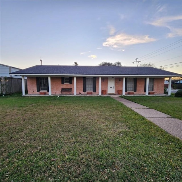 single story home with a front yard, fence, and brick siding