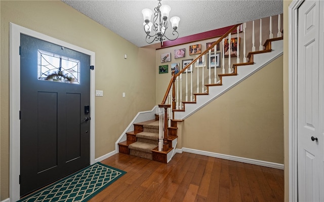 foyer with hardwood / wood-style flooring, a chandelier, and a textured ceiling