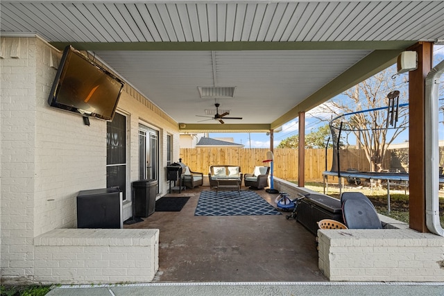 view of patio / terrace with a trampoline, an outdoor living space, and ceiling fan