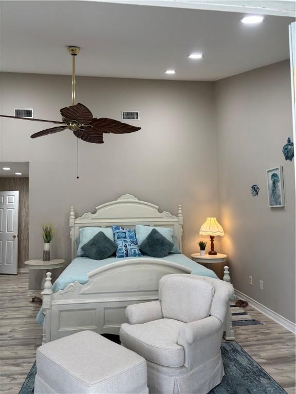 bedroom with ceiling fan, light hardwood / wood-style flooring, and high vaulted ceiling