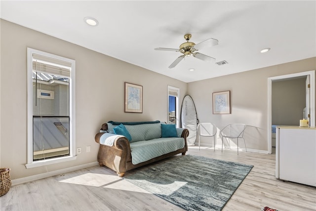 living room with light wood-type flooring and ceiling fan