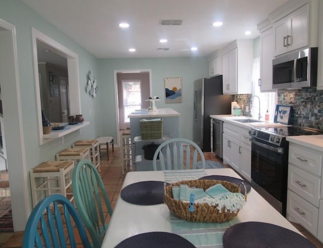 13525 Bullion Ct, Corpus Christi, TX 78418 - kitchen featuring appliances with stainless steel finishes, tasteful backsplash, white cabinetry, light countertops, and recessed lighting