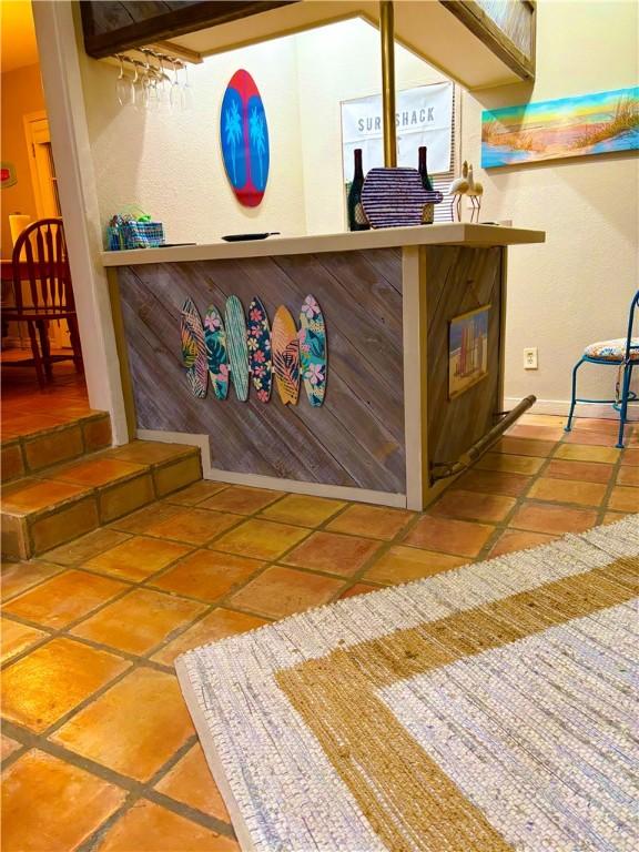 bar with track lighting, ceiling fan, and tile patterned floors