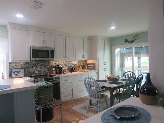 13525 Bullion Ct, Corpus Christi, TX 78418 - kitchen with stainless steel appliances, tasteful backsplash, light countertops, white cabinetry, and recessed lighting