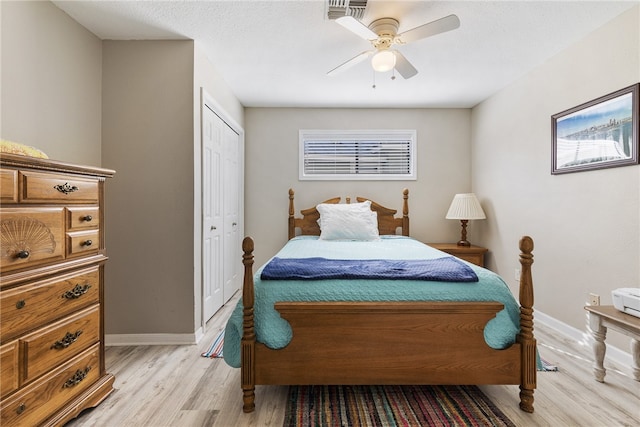 bedroom featuring ceiling fan, a closet, and light hardwood / wood-style flooring