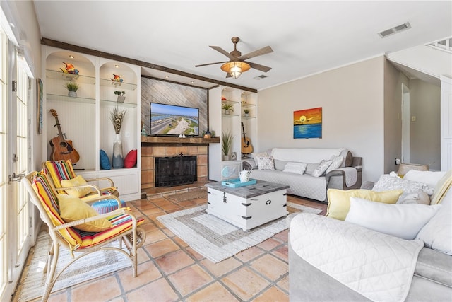 tiled living room featuring ceiling fan and a tile fireplace